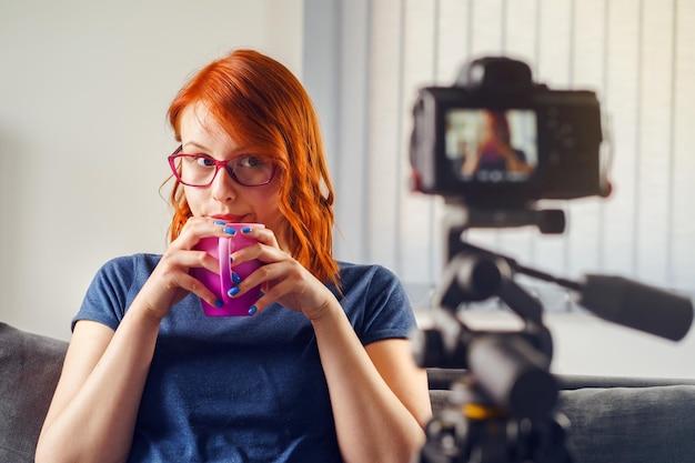 Foto portret van een vrouw met een camera terwijl ze thuis zit