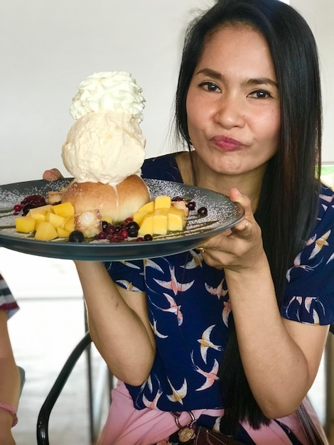 Foto portret van een vrouw met een dessert op een bord