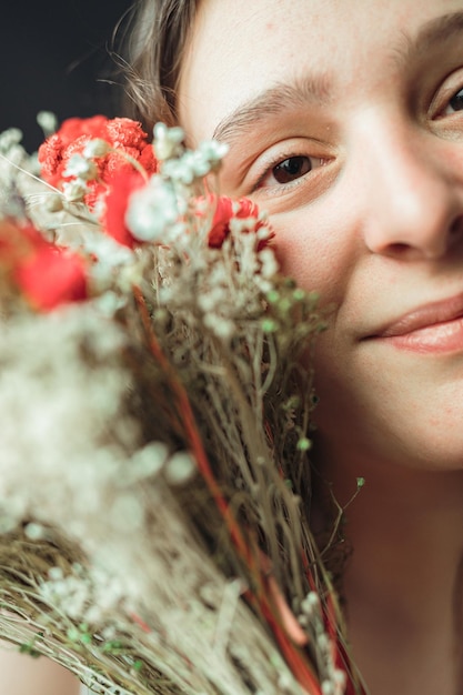 Portret van een vrouw met een kleurrijk boeket bloemen Schoonheid, wellness of huidverzorging met lente-esthetiek op de achtergrond Meisje en anjerplant voor cosmetische gezondheid, huidgloed en blij voor groei