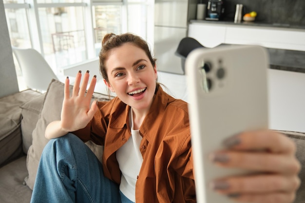 Portret van een vrouw met een mobiele telefoon terwijl ze op tafel zit