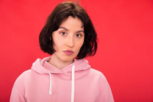 Portret van een vrouw met een roze gezicht op een rode achtergrond