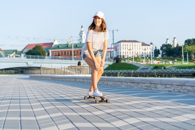 Portret van een vrouw met een skateboard op straat, buitenshuis.