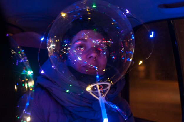 Foto portret van een vrouw met een verlichte ballon's nachts