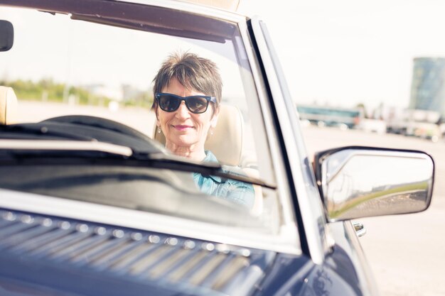 Foto portret van een vrouw met een zonnebril terwijl ze in een auto zit