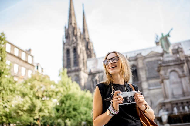 Portret van een vrouw met fotocamera die voor de beroemde kathedraal in de stad Clermont-Ferrand in Frankrijk reist