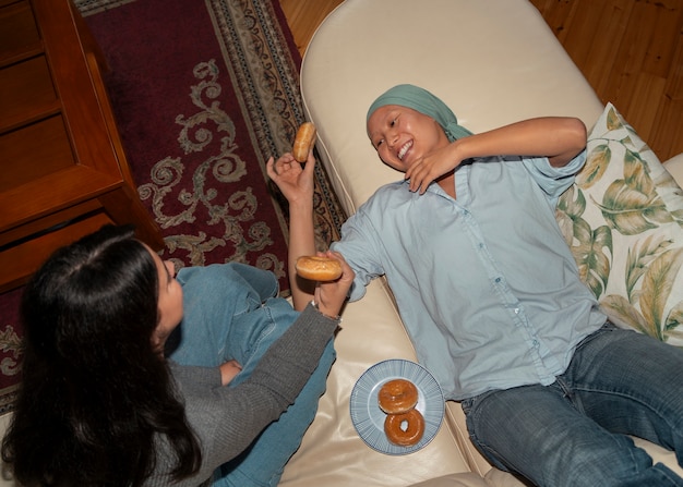 Foto portret van een vrouw met kanker die tijd doorbrengt met haar vriendin thuis