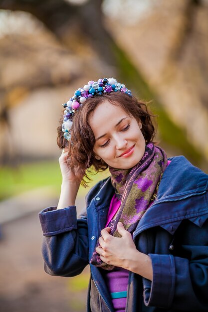 Portret van een vrouw met kort haar en een krans van bloemen op haar hoofd