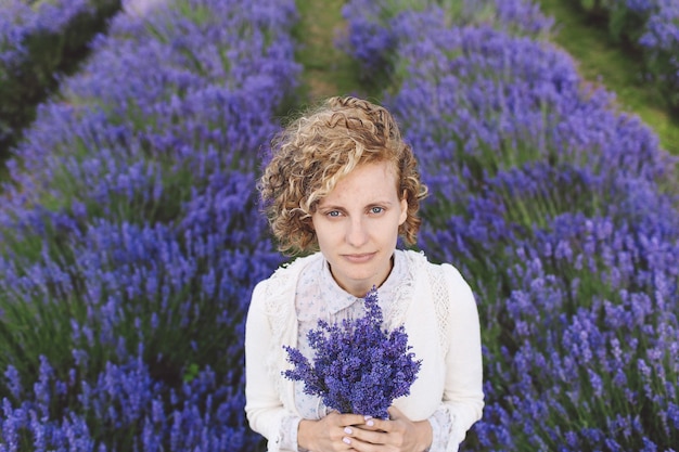 Portret van een vrouw met lavendels terwijl ze op het veld staat