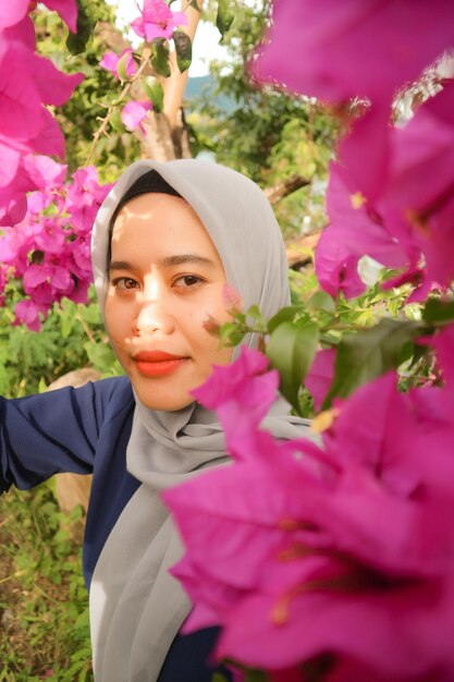 Foto portret van een vrouw met roze bloemen