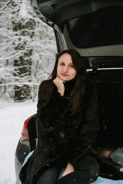 Portret van een vrouw op de achtergrond van een besneeuwd bos