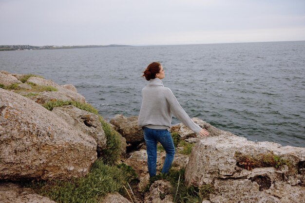 Portret van een vrouw vrijheidswandeling op de stenen kust vrouwelijke ontspannen