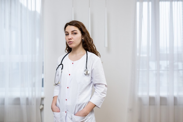 Portret van een vrouwelijke arts in witte medische kleding met een statoscope