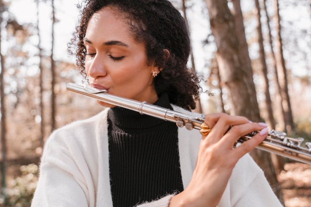 Foto portret van een vrouwelijke muzikant die een blaasinstrument speelt voor de wereldmuziekdag