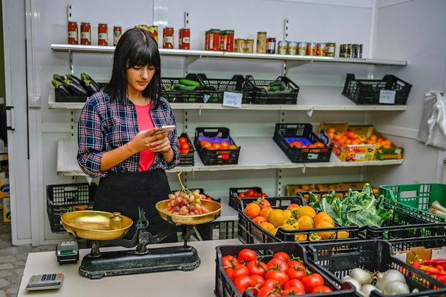 Portret van een winkelier in de fruitwinkel die een bestelling opneemt via de mobiele telefoon