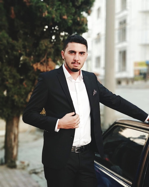 Portret van een zakenman die bij de auto staat