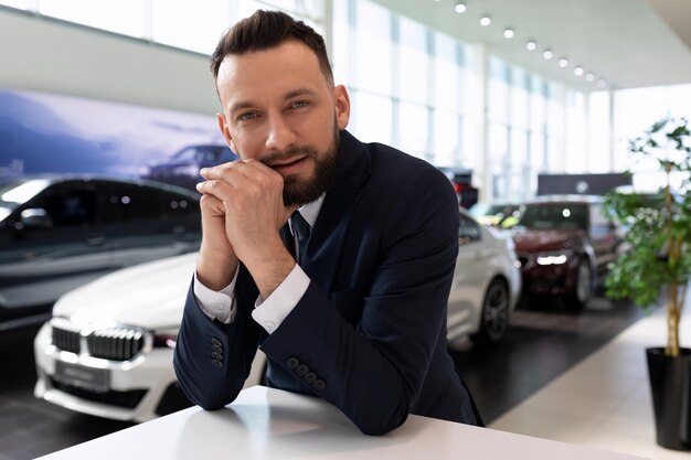 Portret van een zakenman in de autoshowroom van een autodealer