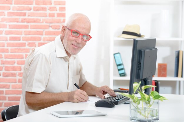 Foto portret van een zakenman met een computer aan zijn bureau