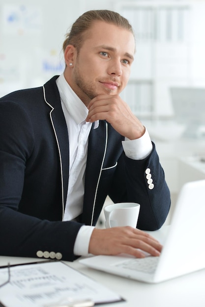 Portret van een zakenman met een laptop op kantoor