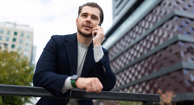 Portret van een zakenman tegen de achtergrond van de gevel van een stijlvol kantoorgebouw