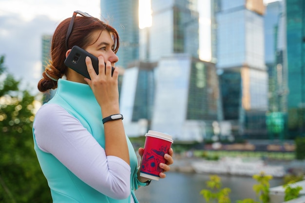 Portret van een zakenvrouw die aan de telefoon praat met een kopje koffie