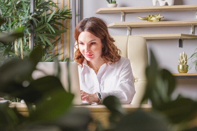 Portret van een zakenvrouw in een witte blouse aan een bureau