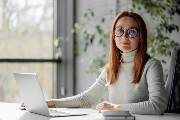 Portret van een zakenvrouw met een bril aan haar bureau