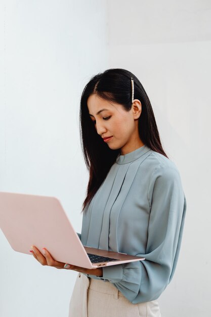Portret van een zakenvrouw met een laptop op een witte achtergrond