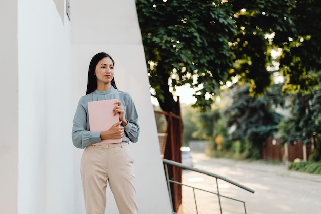 Portret van een zakenvrouw met een laptop op een witte achtergrond