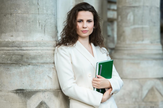 Portret van een zakenvrouw met een notitieboekje in haar hand.