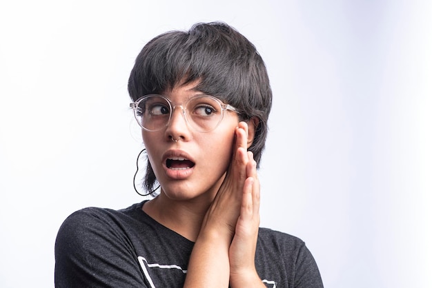 Portret van een zeer jonge mooie Latijns-vrouw op een witte achtergrond zeer verrast