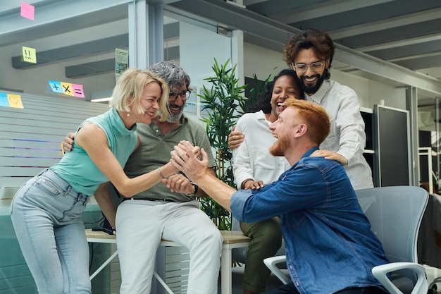 Foto portret van een zeer opgewonden multiracial werkteam dat een nieuw professioneel succes viert