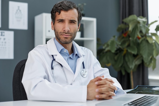 Portret van een zelfverzekerde jonge dokter op kantoor