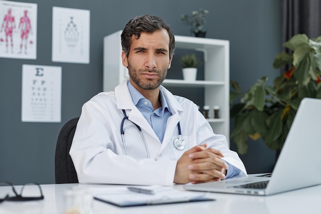 Portret van een zelfverzekerde jonge dokter op kantoor