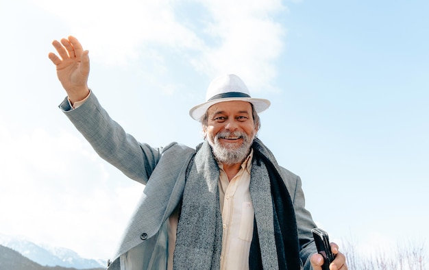 Portret van een zelfverzekerde knappe volwassen man gepensioneerde grootvader in het kleine stadje