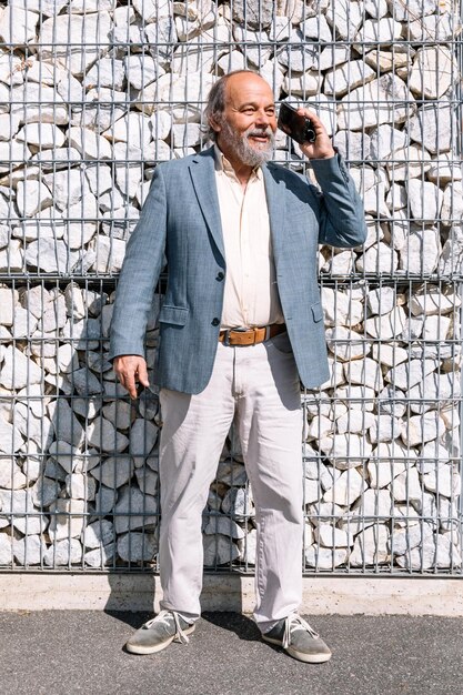 Portret van een zelfverzekerde knappe volwassen man gepensioneerde grootvader in het kleine stadje