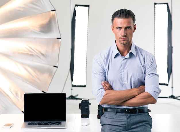 Portret van een zelfverzekerde zakenman die met gevouwen armen in de studio staat