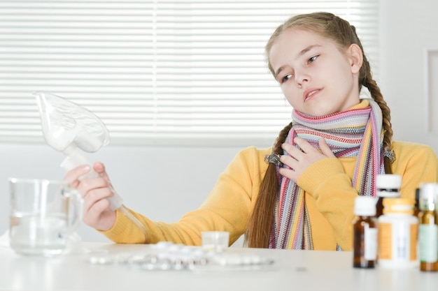 Portret van een ziek meisje met inhalator thuis