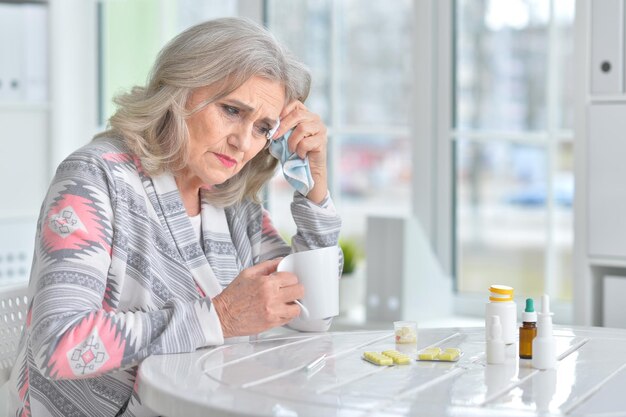 Portret van een zieke bejaarde vrouw met medicijnen