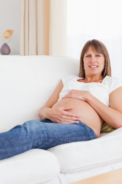 Portret van een zwangere vrouw die haar buik houdt