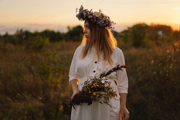 Portret van een zwangere vrouw een mooie jonge zwangere vrouw in een witte jurk loopt in het veld