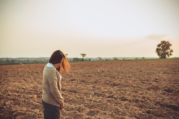 Portret van eenzame vrouw alleen in een veld Vintage filterstijl, ze liefdesverdriet van het liefdesverdriet meisje concept op zonsondergang vintage stijl