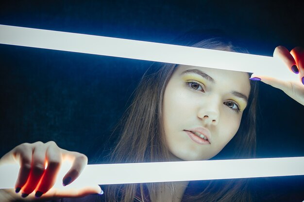 Portret van elegante mooie vrouw poseren met gloeiende neonlichten