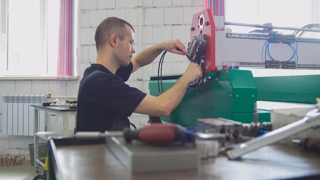 Portret van elektricien op overall werkt met energiepaneel en machineapparatuur op fabriek