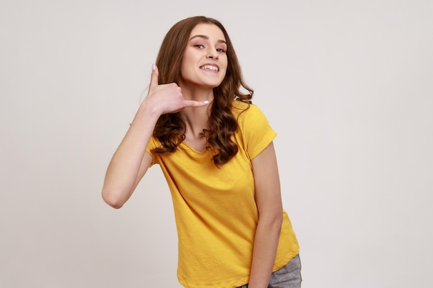 Portret van emotionele jonge vrouw op grijze achtergrond