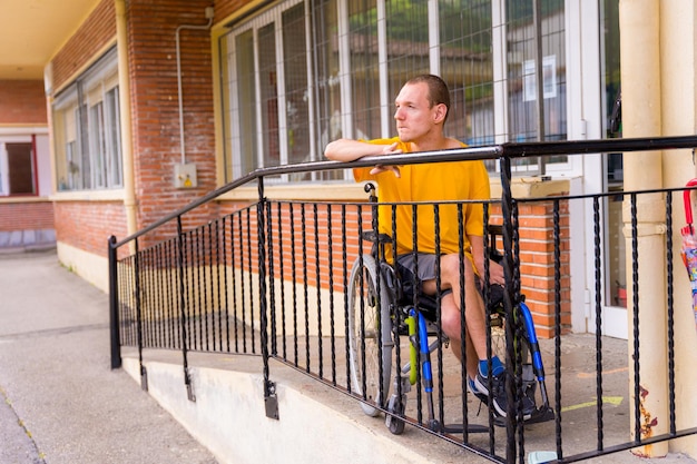 Portret van ernstig gehandicapte in gele jurk in rolstoel op school