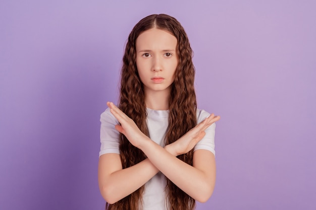 Portret van ernstige brunette kapsel meisje show stopbord gekruiste handen geïsoleerd op violet background