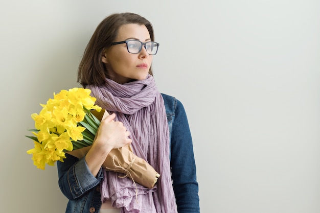 Portret van ernstige vrouw in glazen met boeket