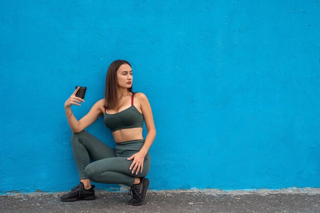 Portret van fitness vrouw in sportkleding poseren geïsoleerd