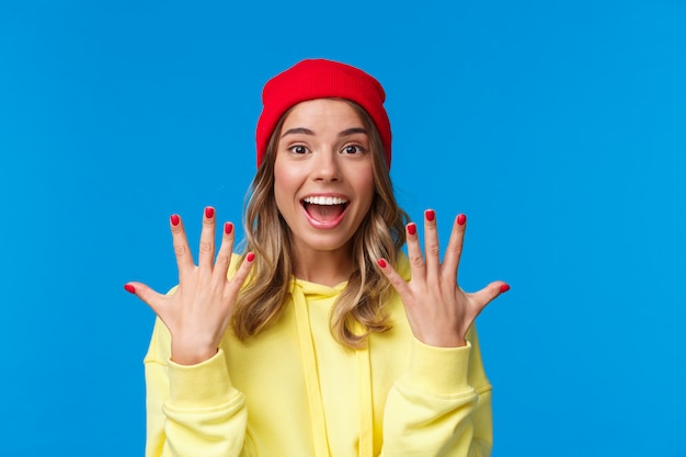 Portret van geamuseerd knap blonde hipster meisje dat vreugdevol glimlacht