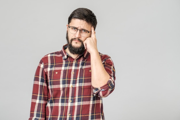 Portret van geconcentreerd slim mannelijk model met met nadenkende bepaalde uitdrukking